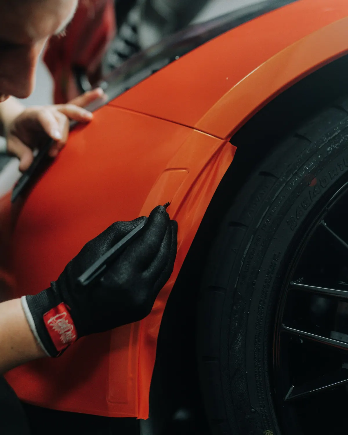 Applicazione di pellicola arancione sulla carrozzeria di un'auto
